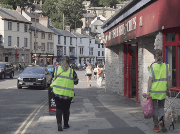 The litter-picking team walk along the roadside through Matlock Bath, passing one of many bustling fish and chip shops.